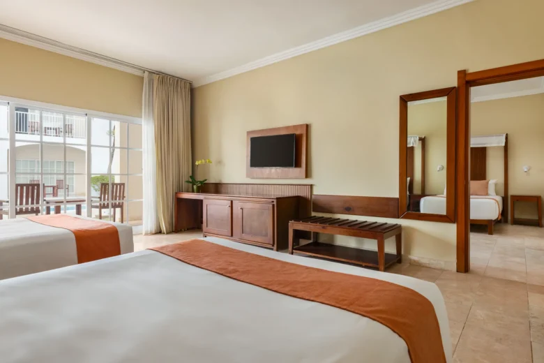 Deluxe Family Room with double beds and furnished balcony at Sunscape Coco Punta Cana overlooking the gardens.