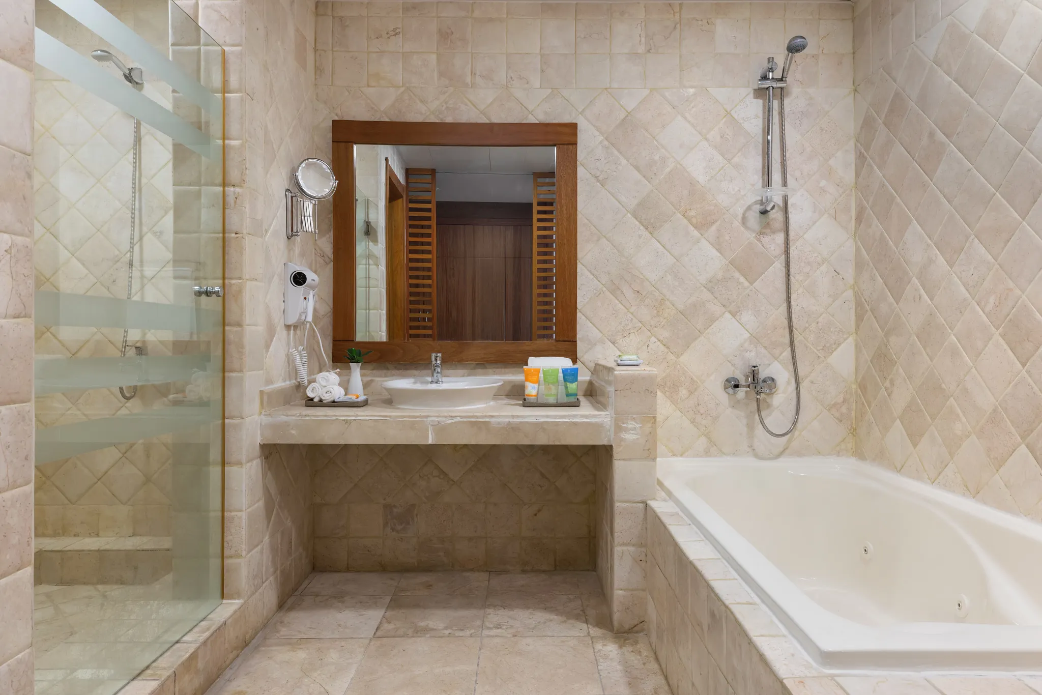 Deluxe Pool View bathroom with walk-in shower, soaking tub, and marble finishes at Sunscape Coco Punta Cana.