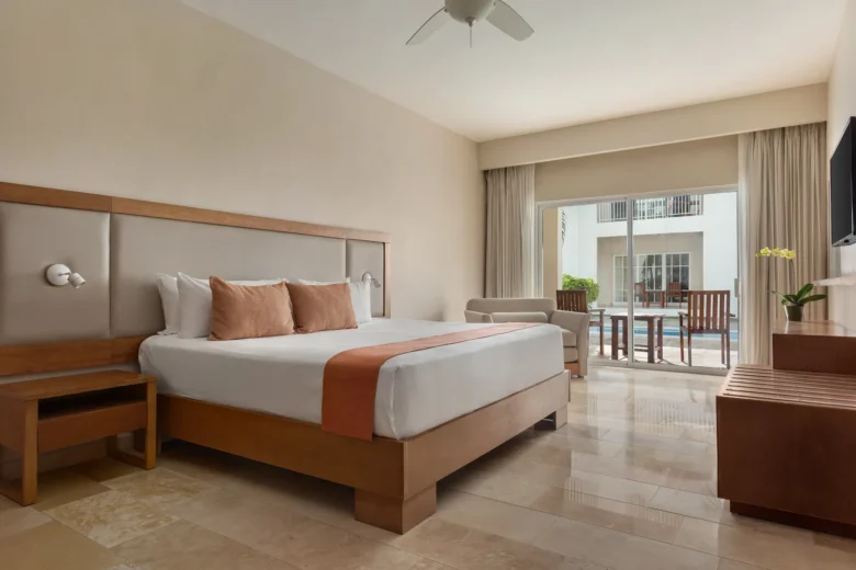 Deluxe Pool View room with king-size bed and private terrace at Sunscape Coco Punta Cana.