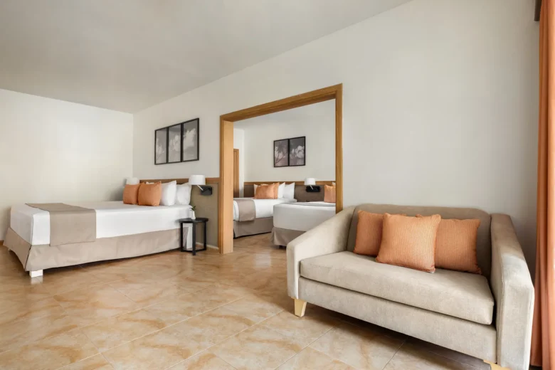 Deluxe Suite with king bed, separate bedroom area, and living space at Sunscape Coco Punta Cana.