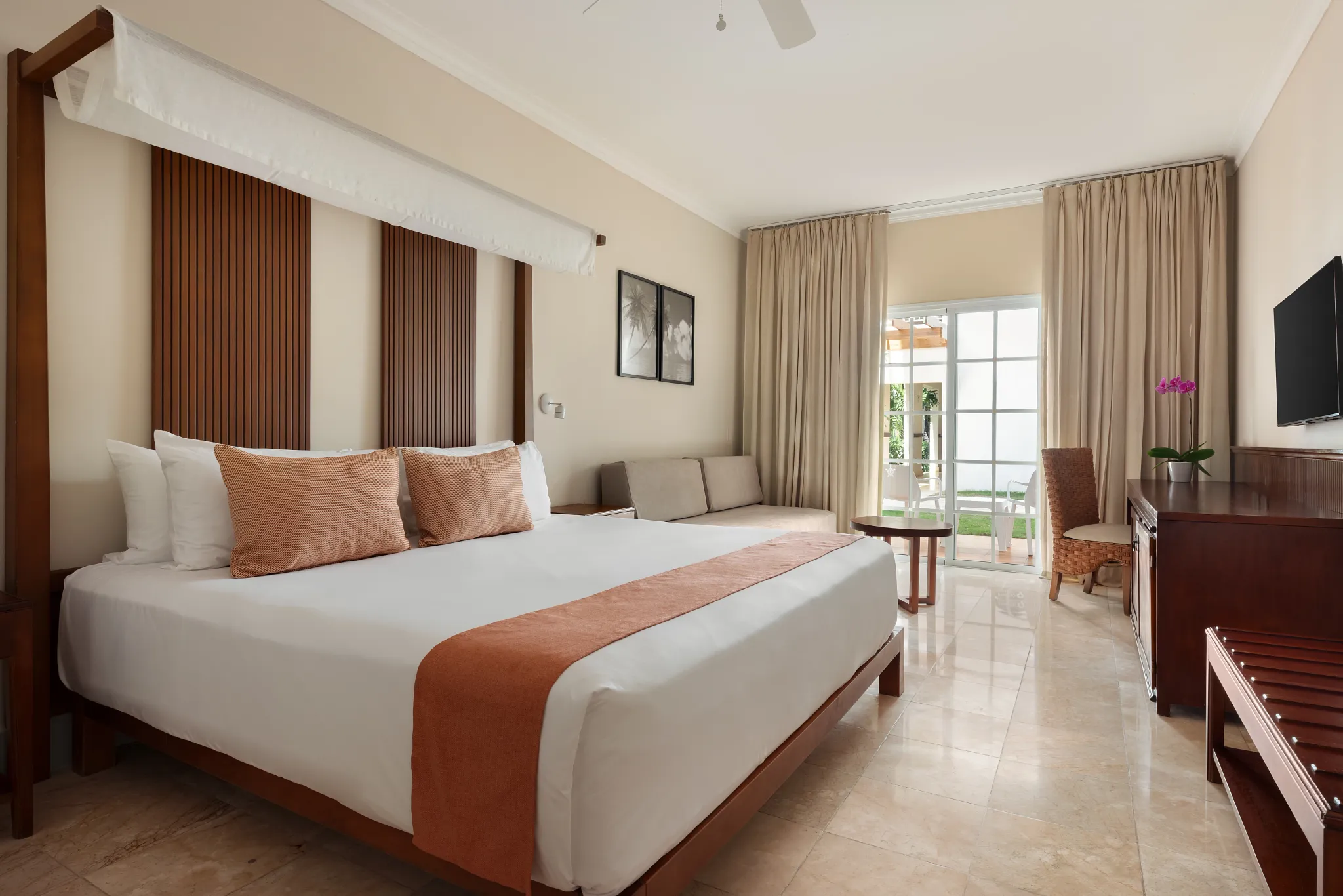 Deluxe Tropical View room with king-size bed and furnished balcony at Sunscape Coco Punta Cana overlooking the gardens.