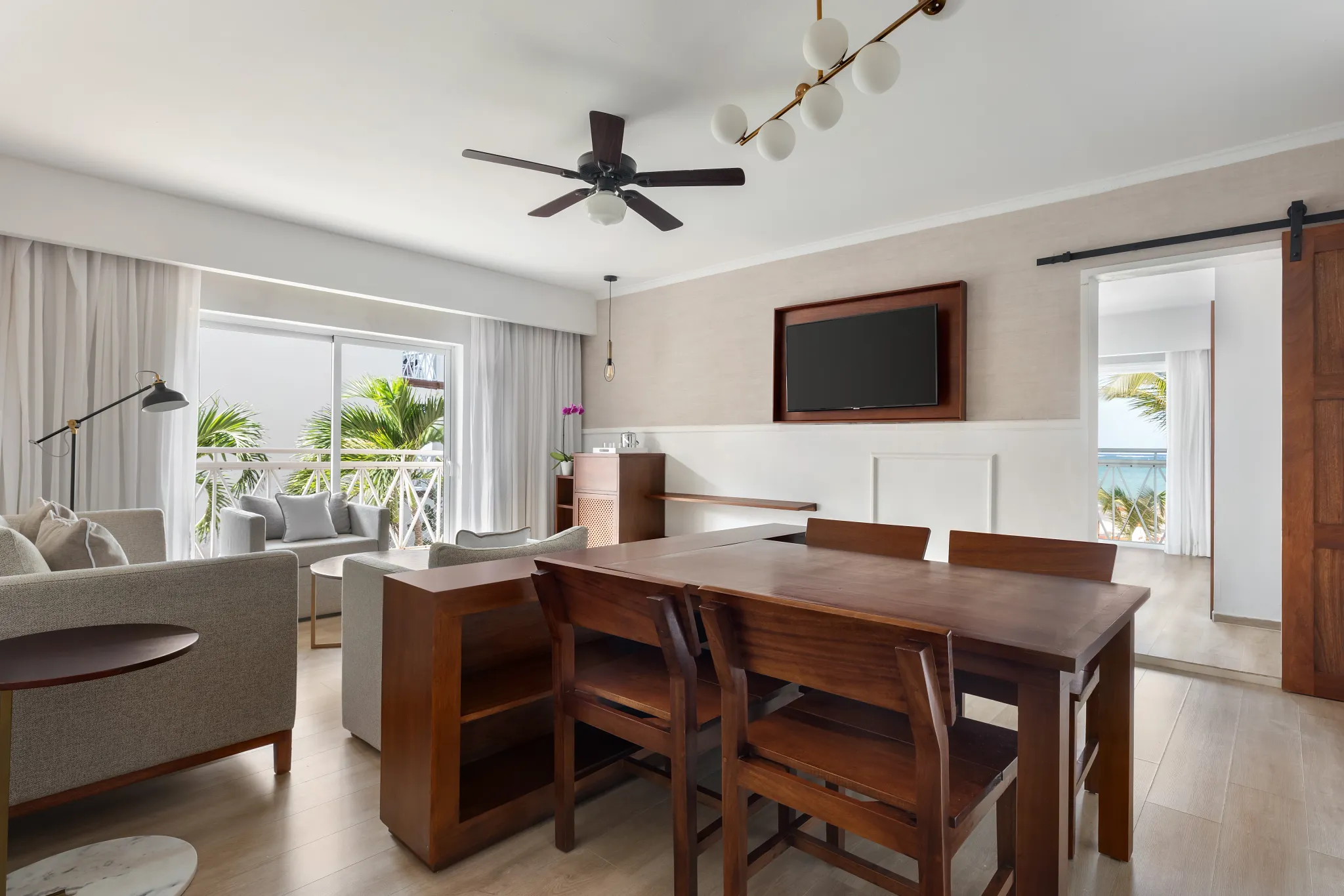 Sun Club 2-Bedroom Family Suite Ocean Front living and dining area at Sunscape Coco Punta Cana with balcony access.