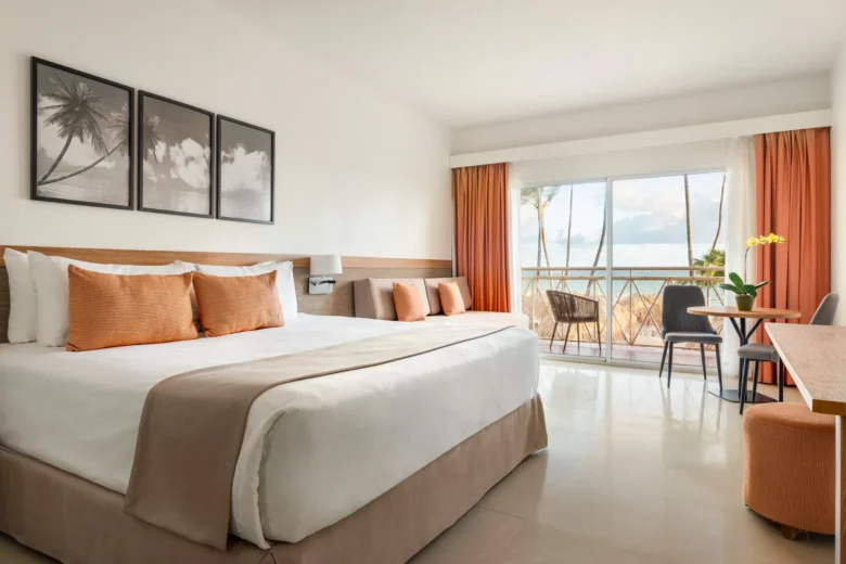 Oceanfront junior suite with king bed and private balcony overlooking the beach at Sunscape Coco Punta Cana.