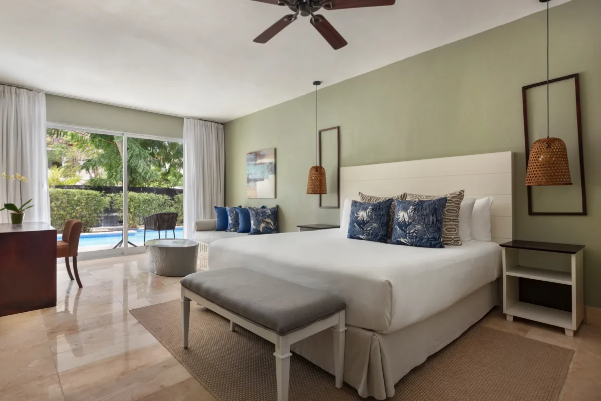 Luxury swim-out junior suite with king bed, tropical décor, and direct pool access at Sunscape Coco Punta Cana.