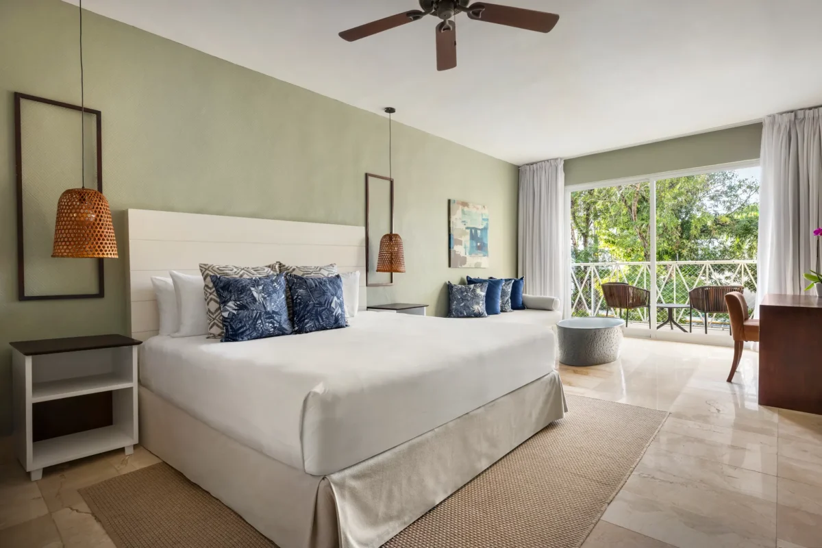 Sun Club Junior Suite Tropical View with king-size bed and private terrace at Sunscape Coco Punta Cana.