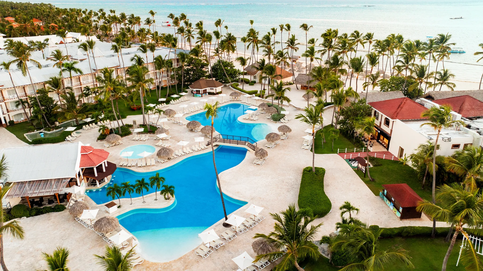 Aerial view of the main resort pool and beachfront at Sunscape Coco Punta Cana.