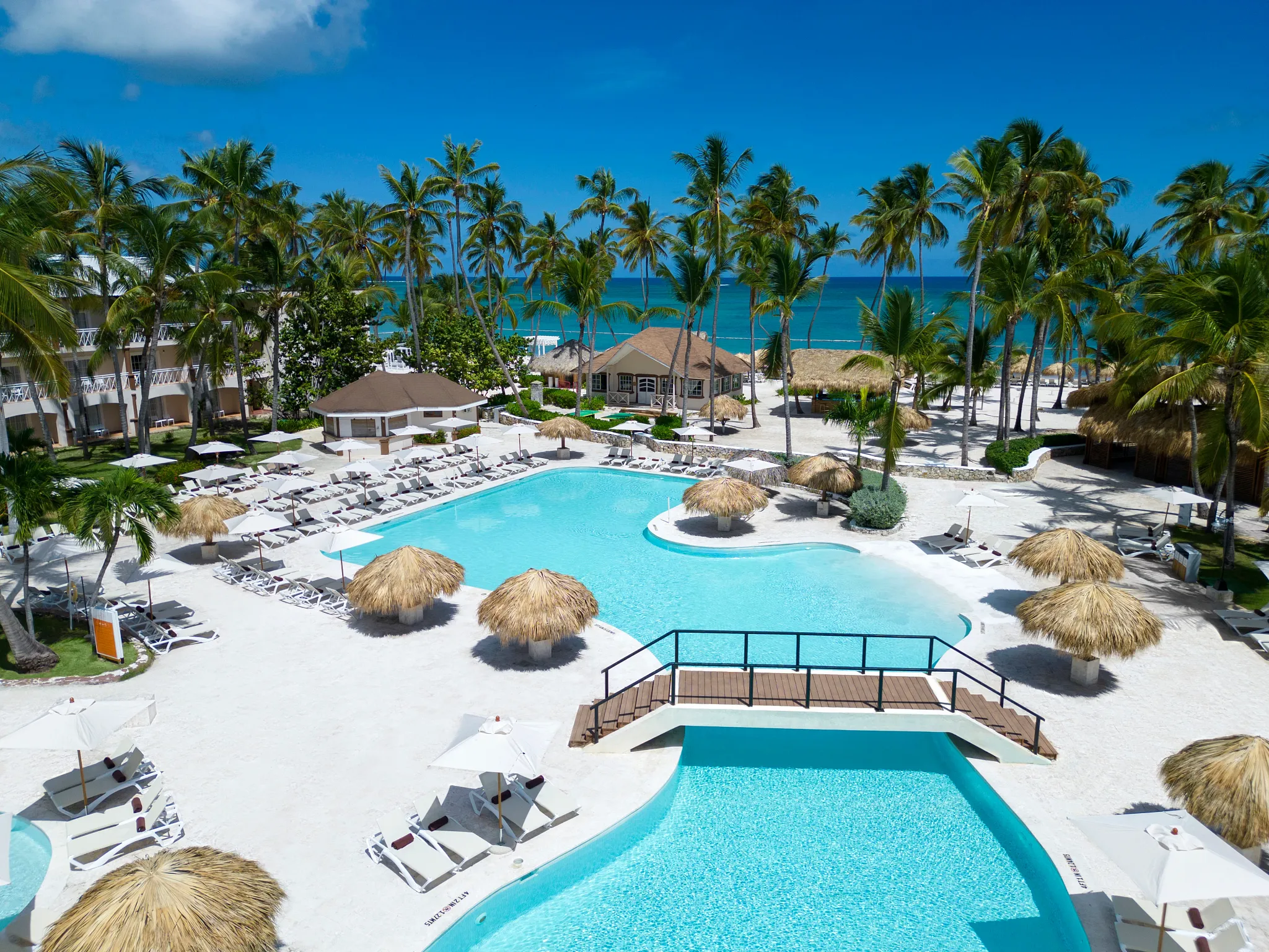 Aerial view of the main pool area with beach access at Sunscape Coco Punta Cana Resort.