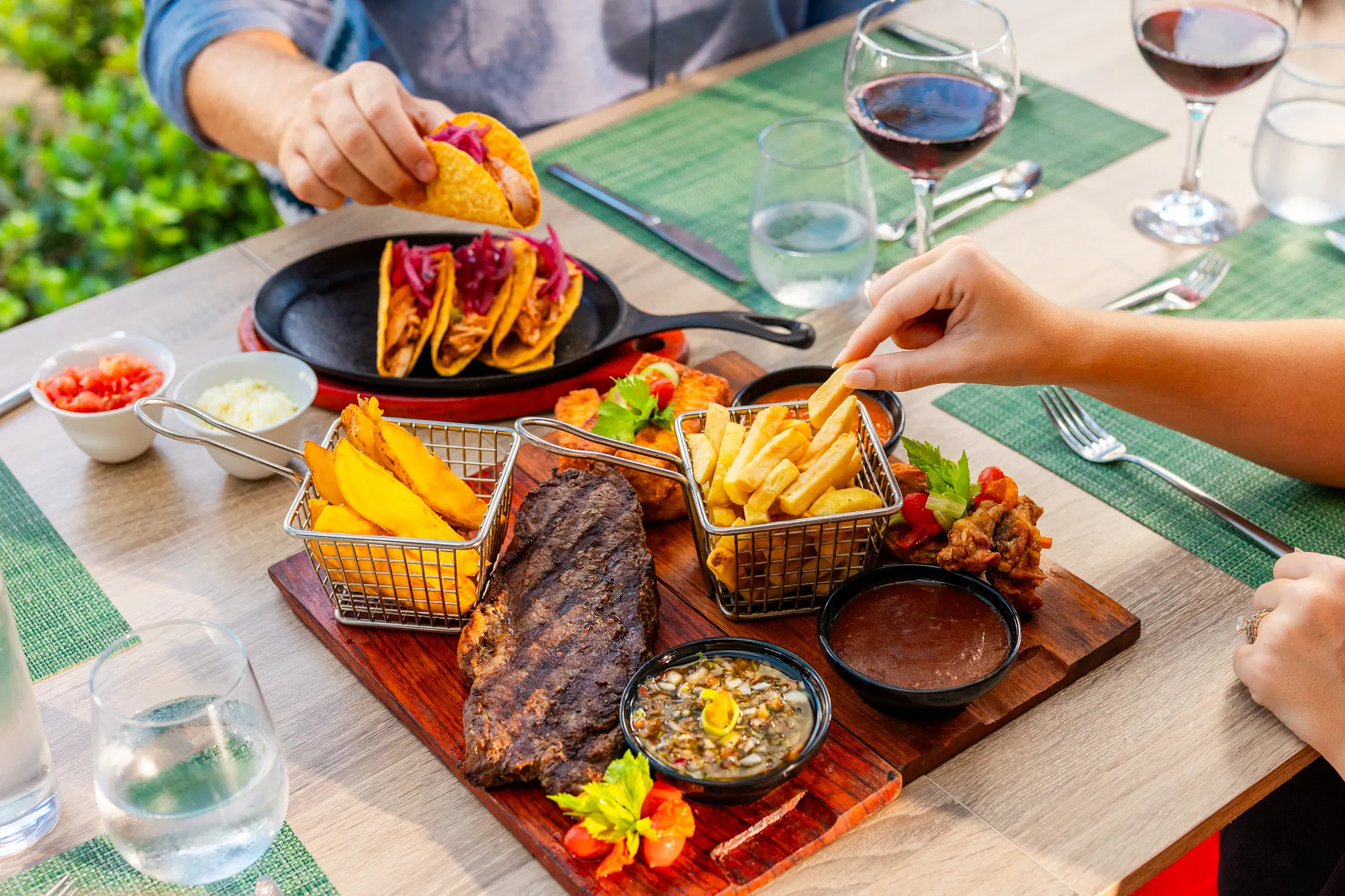 Guests enjoying tacos, ribs, fries, and drinks during an outdoor dining experience at Sunscape Coco Punta Cana Resort.