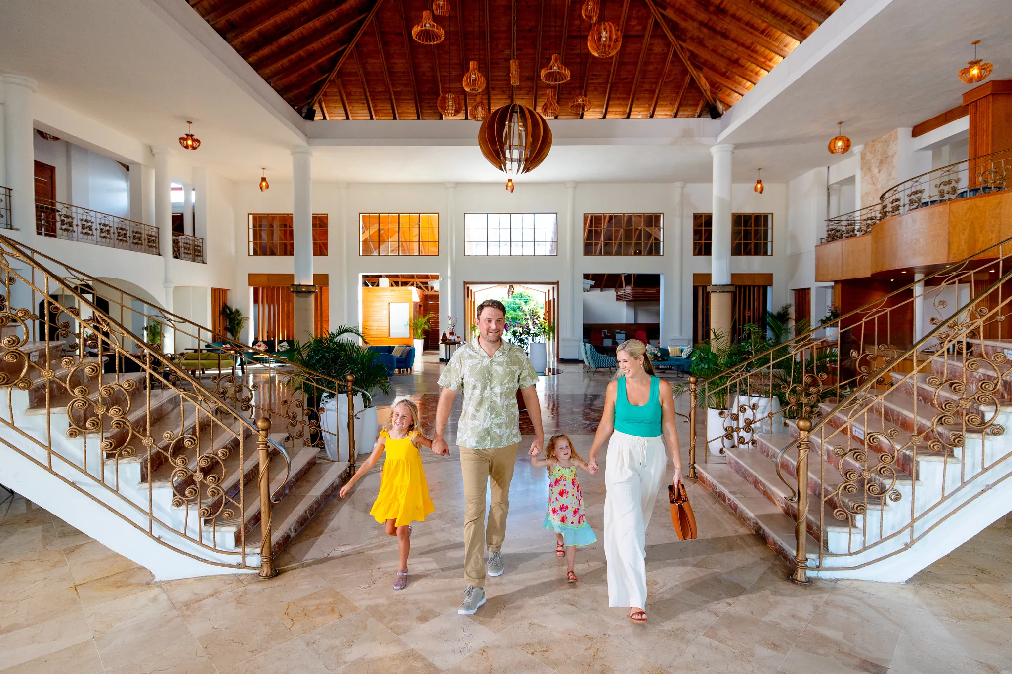 Family walking through the spacious lobby at Sunscape Coco Punta Cana Resort.