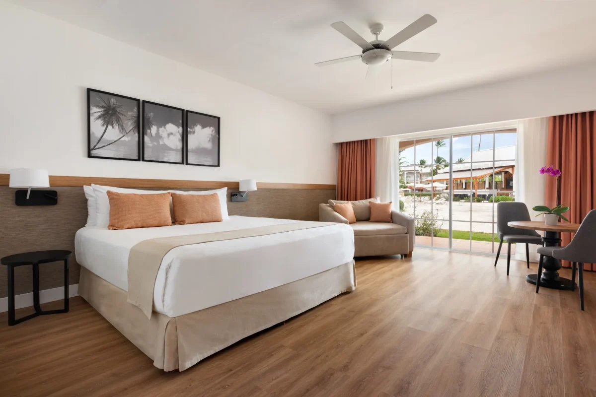 Superior Deluxe Pool View room with king-size bed and terrace at Sunscape Coco Punta Cana overlooking the pool area.